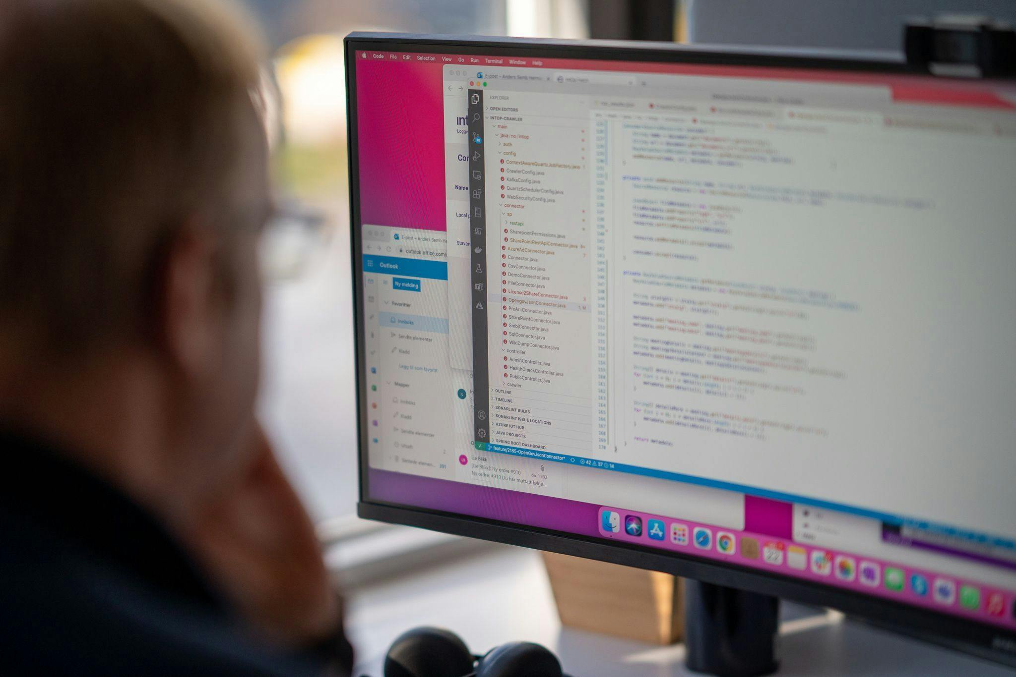 Person looking at code in front of a external monitor